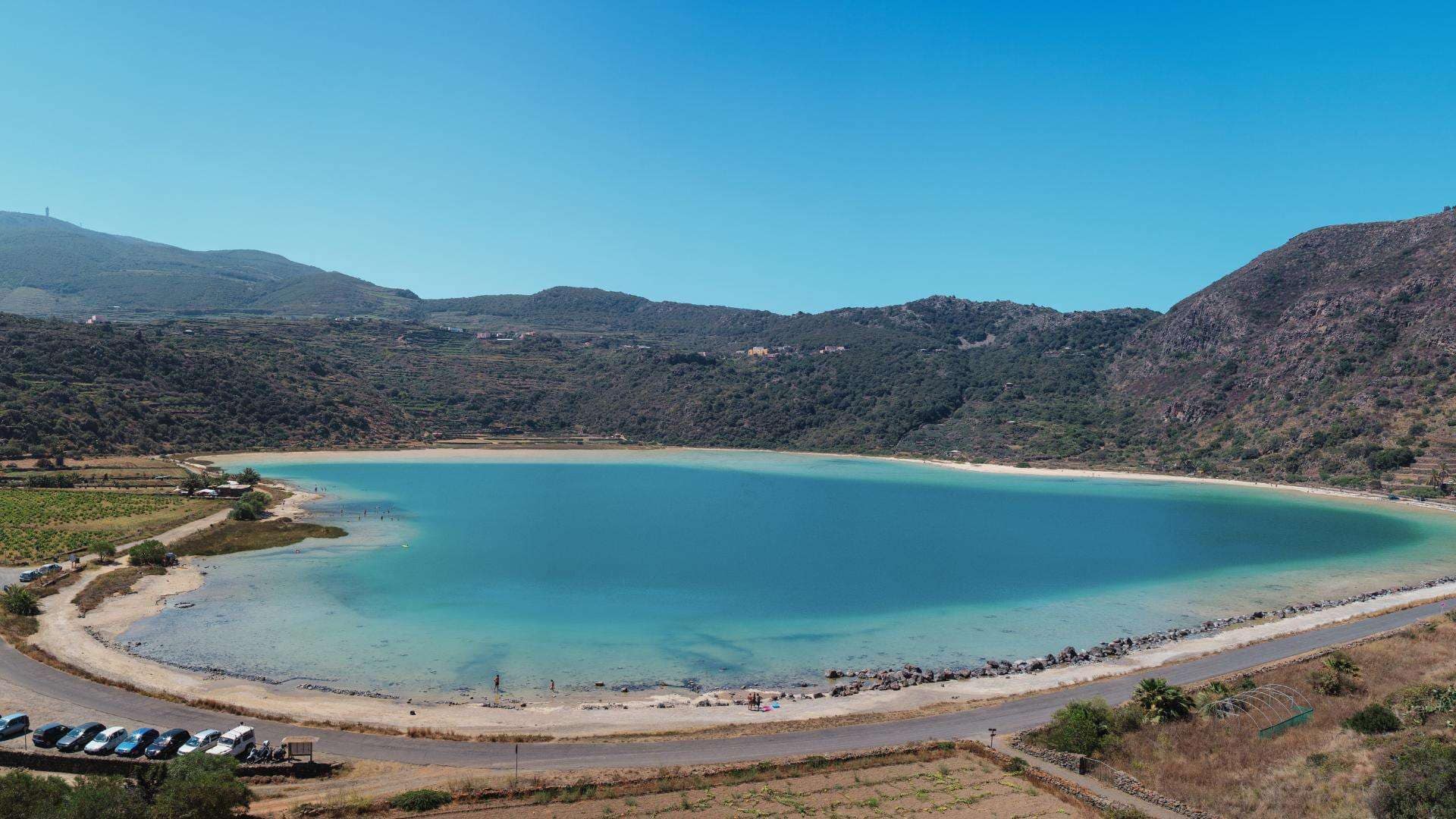 Spectaculair uitzicht op Lago Specchio di Venere op het eiland Pantelleria, ook wel de Zwarte Parel van de Middellandse Zee genoemd, met turquoise meer omringd door vulkanische heuvels.